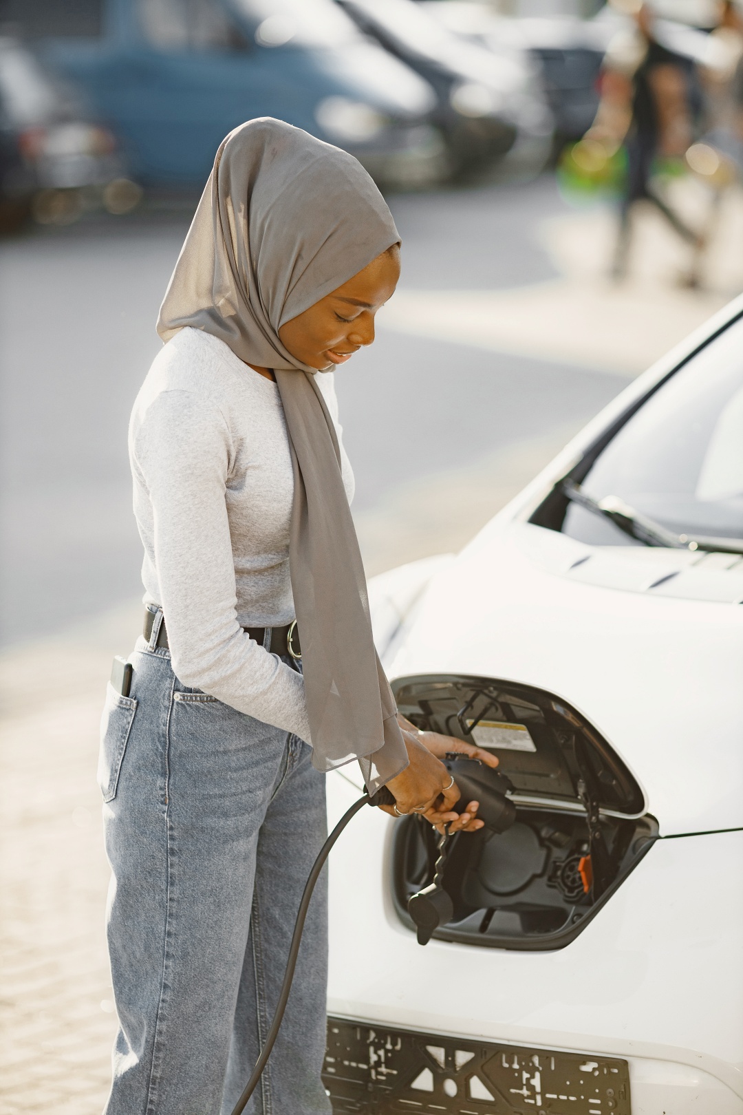 Woman charging electric vehicle